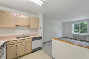 Interior unit kitchen, light brown cabinets, linoleum countertops, tile floor, white walls.