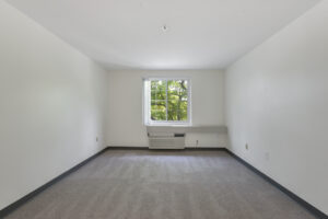 Interior Unit Bedroom, AC below window, new carpeting, white walls.