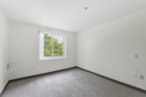 Interior Unit Bedroom, New Carpeting, White walls, window.